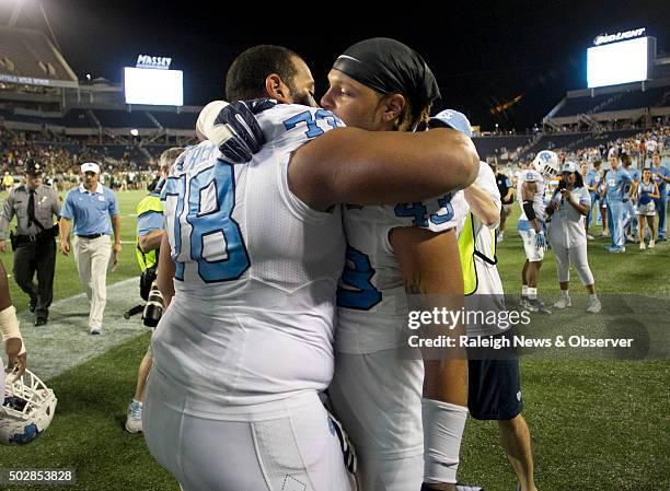North Carolina senior Landon Turner is embraces by teammate Jessie Rogers following their 49-38 loss to Baylor in the Russell Athletic Bowl on...