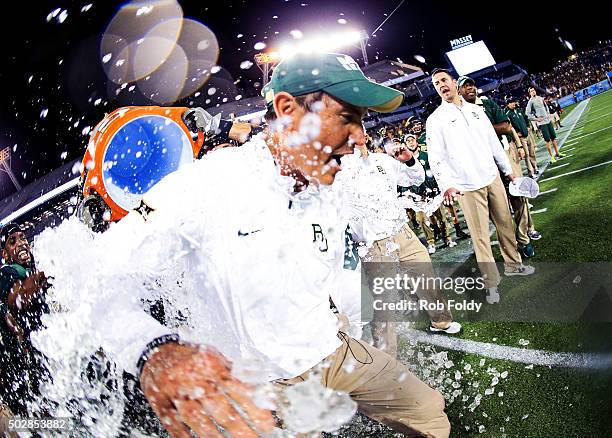 Head coach Art Briles of the Baylor Bears has water dumped on him after the Russell Athletic Bowl game against the North Carolina Tar Heels at...
