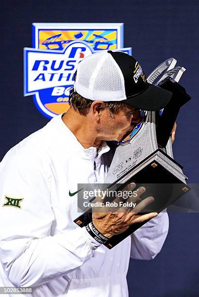 Head coach Art Briles of the Baylor Bears kisses the championship trophy after the Russell Athletic Bowl game against the North Carolina Tar Heels at...