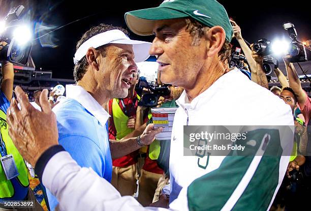 Head coaches Larry Fedora of the North Carolina Tar Heels and Art Briles of the Baylor Bears shake hands after the Russell Athletic Bowl game at...