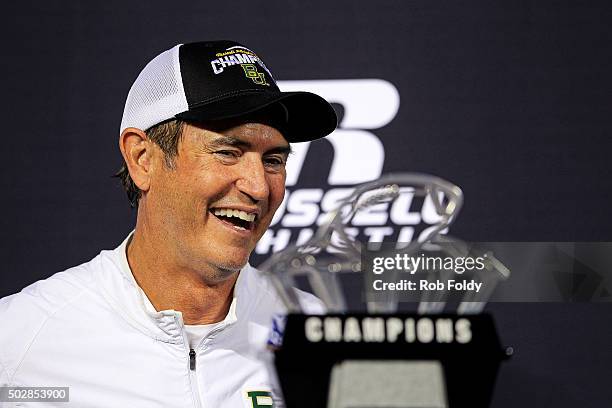Head coach Art Briles of the Baylor Bears looks at the championship trophy after the Russell Athletic Bowl game against the North Carolina Tar Heels...