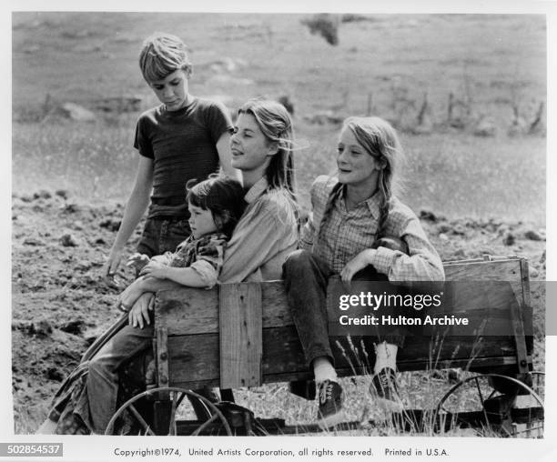 Matthew Burrill, Helen Harmon, Jan Smithers and Julie Gholson sit in a wagon in a scene from the United Artist movie "Where the Lilies Bloom" circa...