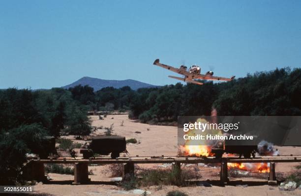 An airplane as explosions go off in a scene from the movie "The Wild Geese" circa 1978.