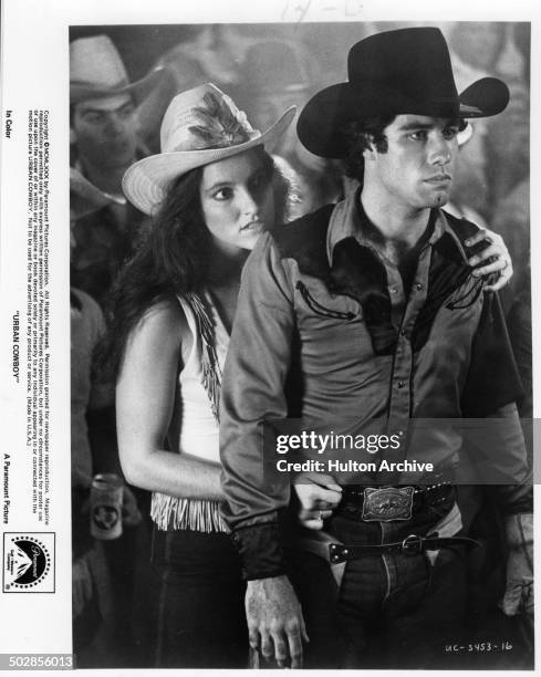 Actor John Travolta and actress Madolyn Smith Osborne look on in a scene during the Paramount Pictures movie 'Urban Cowboy" circa 1980.