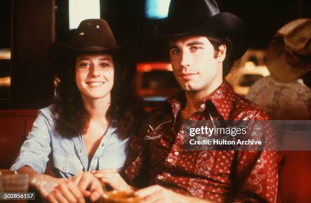 Actor John Travolta and Debra Winger smile on set of the Paramount Pictures movie 'Urban Cowboy" circa 1980.