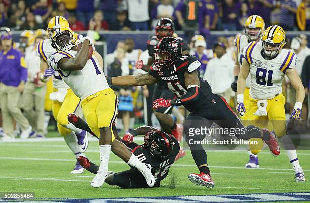 Leonard Fournette of the LSU Tigers runs with the ball as he gets tackeled by Micah Awe of the Texas Tech Red Raiders during the second half of the...