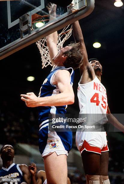 Dan Issel of the Denver Nuggets shoots over Cliff Robinson of the New Jersey Nets during an NBA basketball game circa 1979 at the Rutgers Athletic...