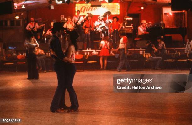 Actor John Travolta and Debra Winger dance at Gilley's in a scene during the Paramount Pictures movie 'Urban Cowboy" circa 1980.