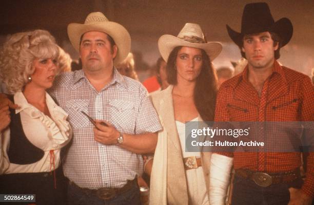Actors Barry Corbin with actress Madolyn Smith Osborne and John Travolta stand in a scene during the Paramount Pictures movie 'Urban Cowboy" circa...