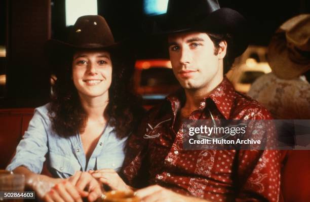 Actor John Travolta and Debra Winger pose in a scene during the Paramount Pictures movie 'Urban Cowboy" circa 1980.