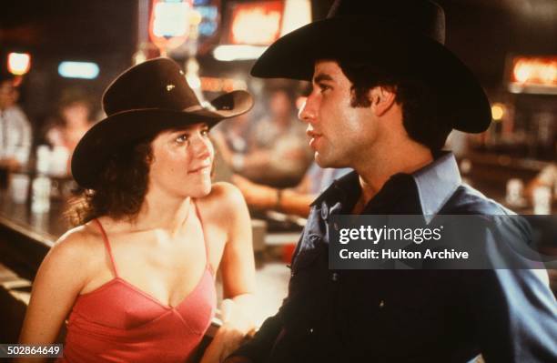 Actor John Travolta and Debra Winger talk in a scene during the Paramount Pictures movie 'Urban Cowboy" circa 1980.