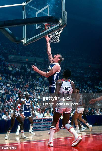 Dan Issel of the Denver Nuggets shoots over Elvin Hayes of the Washington Bullets during an NBA basketball game circa 1979 at the Capital Centre in...