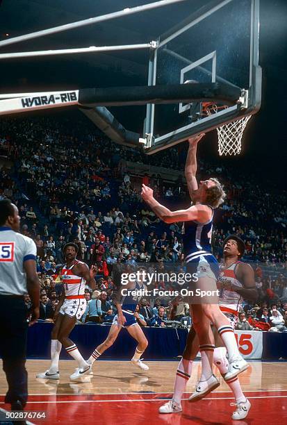 Dan Issel of the Denver Nuggets shoots over Wes Unseld of the Washington Bullets during an NBA basketball game circa 1978 at the Capital Centre in...