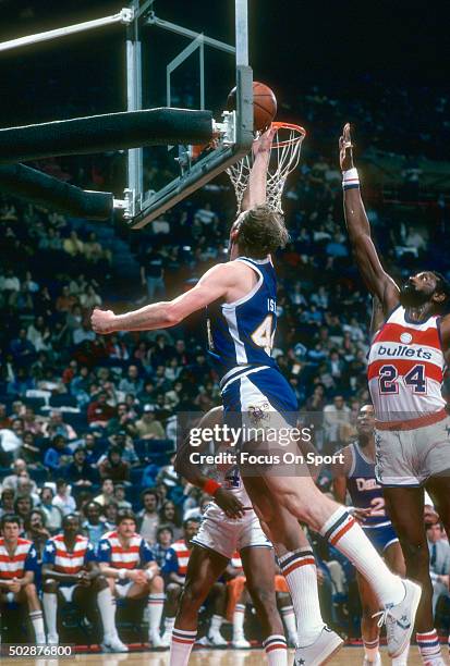 Dan Issel of the Denver Nuggets shoots over Spencer Haywood of the Washington Bullets during an NBA basketball game circa 1982 at the Capital Centre...