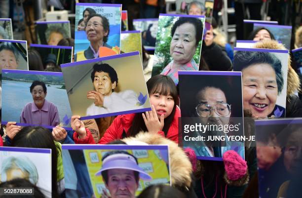 South Korean supporters hold portraits of former "comfort women", who were forced into wartime sexual slavery for Japanese soldiers, during an...