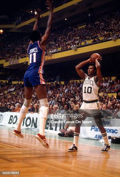 Jo Jo White of the Boston Celtics looks to pass the ball over Caldwell Jones of the Philadelphia 76ers during an NBA basketball game circa 1976 at...
