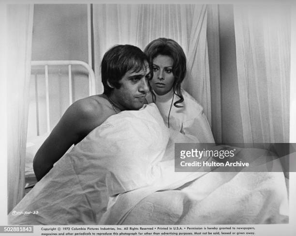 Adriano Celentano sits up in bed with Sophia Loren in a scene from the movie "White Sister" circa 1972.