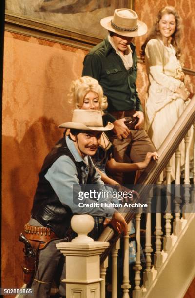 Richard Benjamin and James Brolin walk upstairs with women robots in a scene from the MGM movie "Westworld" circa 1973.