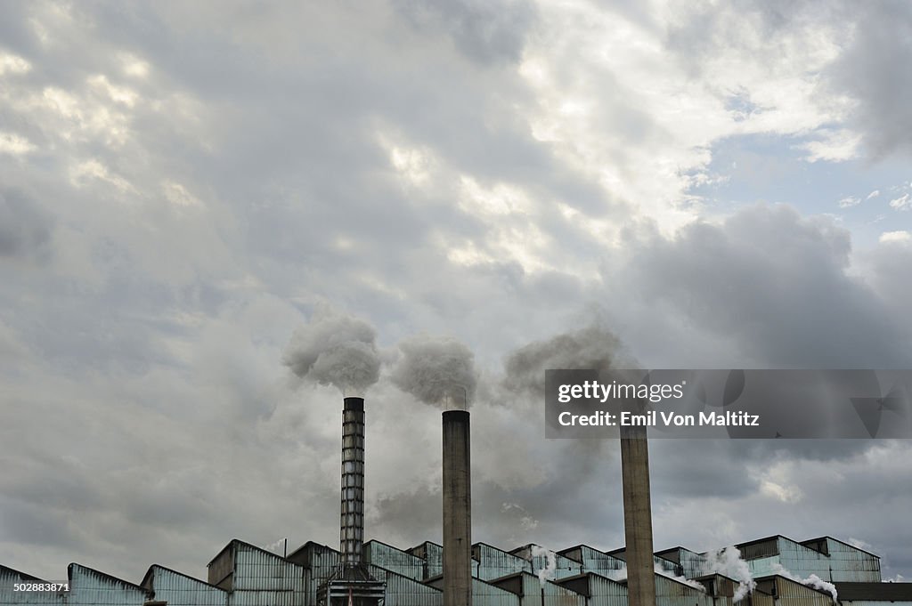 Low angle view of sugar refinery smoke stacks.