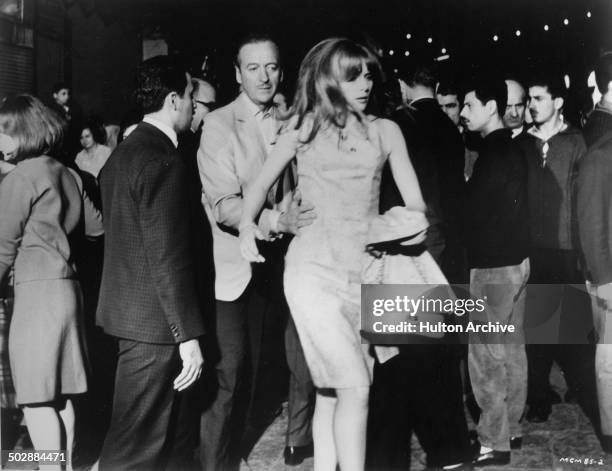 David Niven and Francoise Dorleac move in a crowd in a scene from the MGM movie "Where the Spies Are" circa 1965.