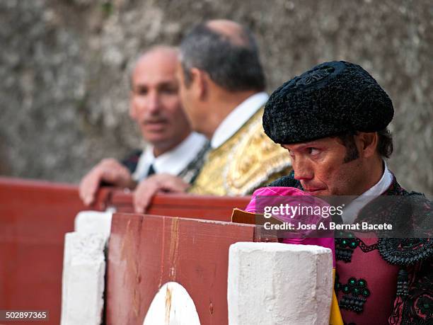 Bullfighter in a refuge in a bull ring looking fíjamente at the bull and with the cape bitten in the mouth by the nerves. Bocairent bullring (the...