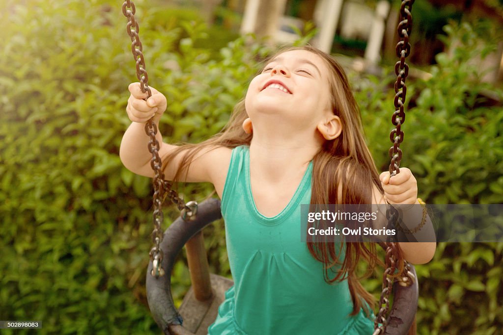 Happy young girl on a swing