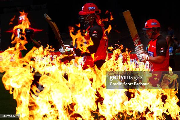 Chris Gayle and Aaron Finch of the Renegades walk through flames to open the batting during the Big Bash League match between the Melbourne Renegades...