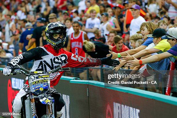 Fans 'high 5' the Freestyle Moto X riders during the Big Bash League match between the Melbourne Renegades and the Perth Scorchers at Etihad Stadium...