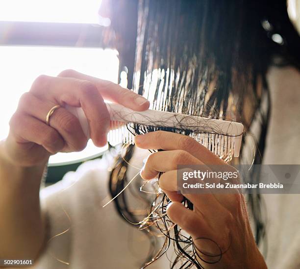 woman took a shower and is combing her wet hair - older woman wet hair stock pictures, royalty-free photos & images