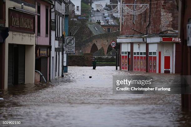 Man wades through the water as the River Nith bursts its banks on December 30, 2015 in Dumfries, Scotland. Severe flooding has affected large parts...