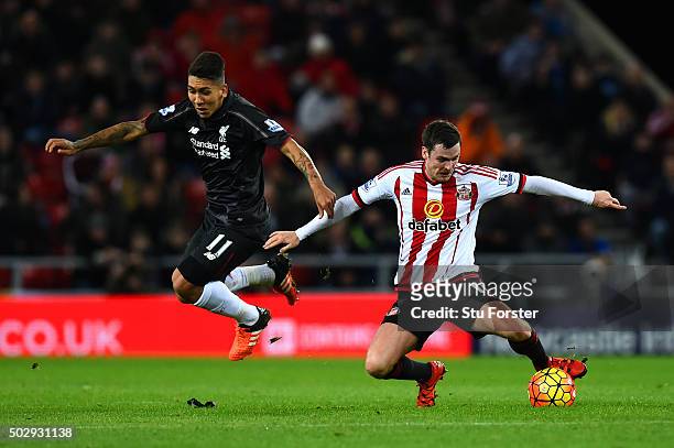 Adam Johnson of Sunderland battles for the ball with Roberto Firmino of Liverpool during the Barclays Premier League match between Sunderland and...
