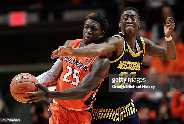 Kendrick Nunn of the Illinois Fighting Illini holds the ball as Caris LeVert of the Michigan Wolverines reaches in at Memorial Stadium on December...