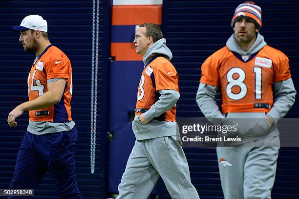 Peyton Manning of the Denver Broncos, center, walks onto the field between Dan Light and Owen Daniels during practice at Dove Valley December 30,...