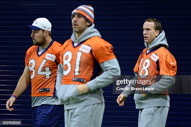 Peyton Manning of the Denver Broncos looks out at the field while walking behind Dan Light and Owen Daniels during practice at Dove Valley December...