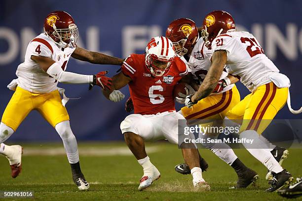 Chris Hawkins of the USC Trojans, Su'a Cravens of the USC Trojans, Osa Masina of the USC Trojans tackle Corey Clement of the Wisconsin Badgers during...
