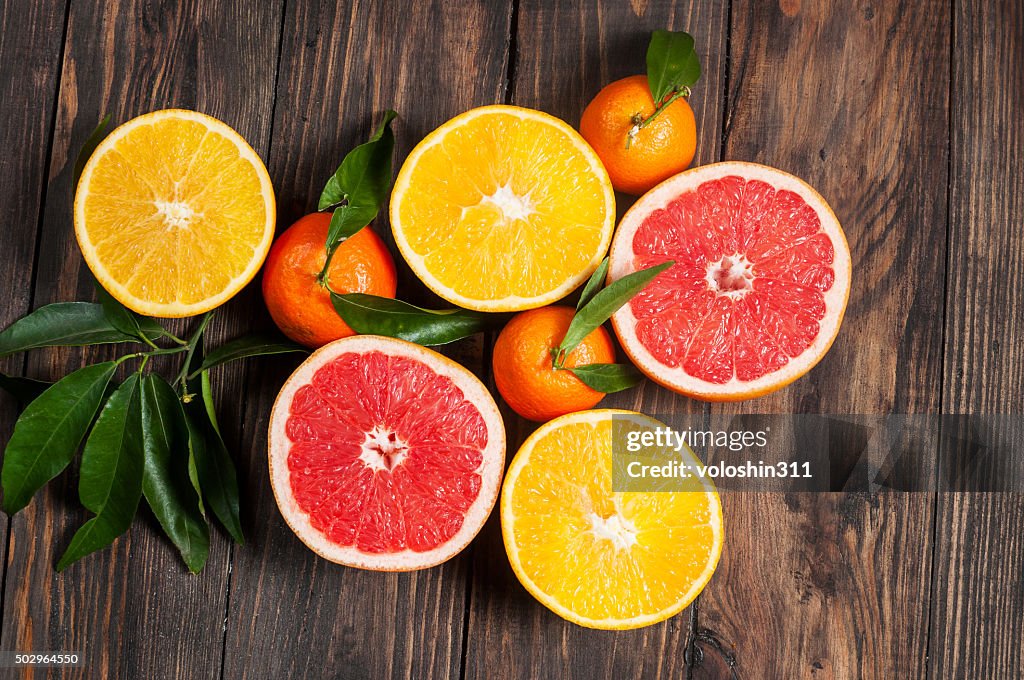 Citrus fruits. Over wooden table background