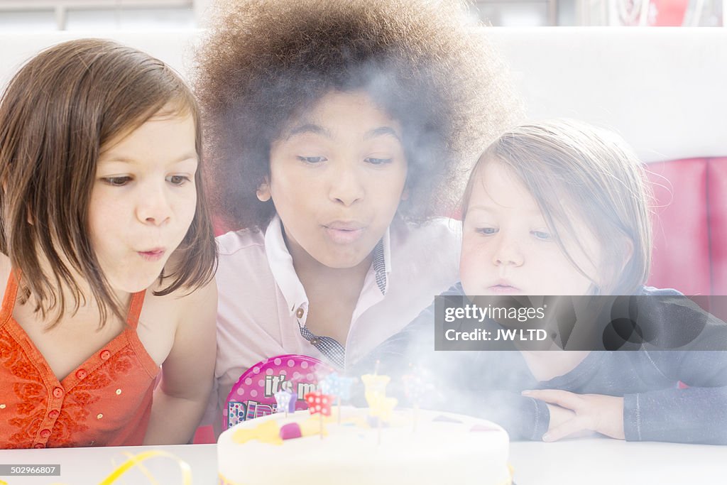 Children's party in diner, blowing out the candles