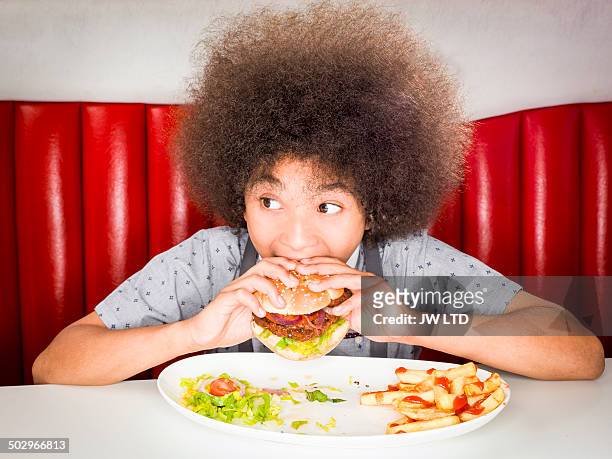 boy (10-11) eating hamburger in american diner - kid eating burger bildbanksfoton och bilder