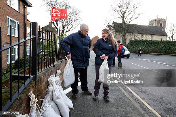 Labour leader Jeremy Corbyn with local MP Rachael Maskell lift sandbags after flooding in York on December 31, 2015 in York, England. The Met Office...