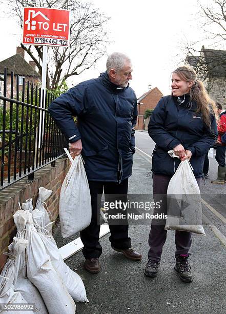 Labour leader Jeremy Corbyn with local MP Rachael Maskell lift sandbags after flooding in York on December 31, 2015 in York, England. The Met Office...