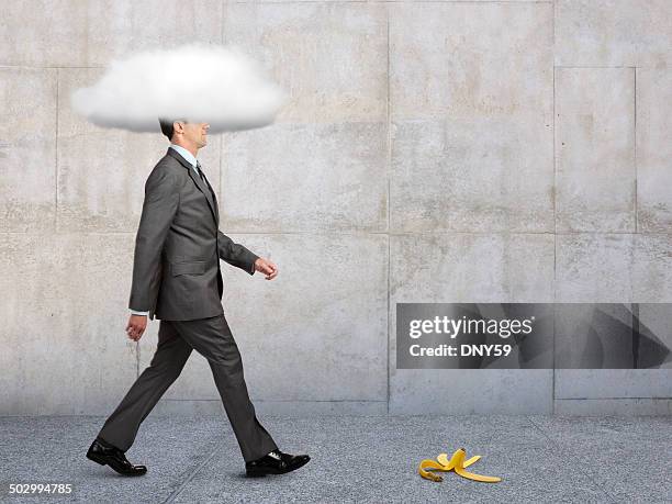 geschäftsmann mit kopf in den wolken mit banana peel im weg - stupid stock-fotos und bilder