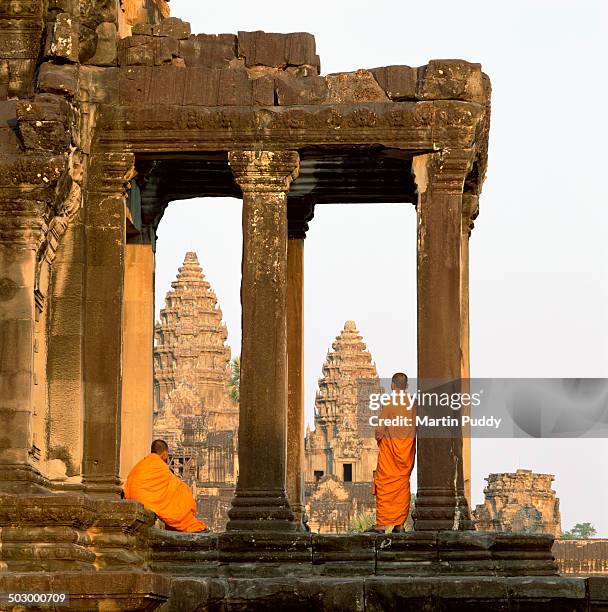 angkor wat, buddhist monks standing amongst ruins - angkor wat stock-fotos und bilder