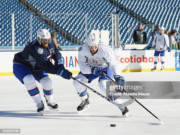 Alex Galchenyuk moves the puck around Greg Pateryn of the Montreal Canadiens during practice at Gillette Stadium on December 31, 2015 in Foxboro,...