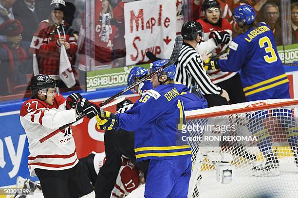 Canada's Mitchell Stephens and Sweden's Carl Grundstrom have a brawl during the 2016 IIHF World Junior U20 Ice Hockey Championships tournament match...