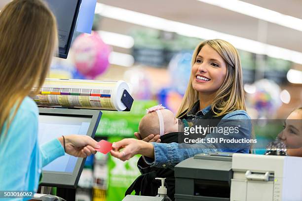 kunden mit loyalty card oder kreditkarte bezahlen im supermarkt - customer loyalty stock-fotos und bilder
