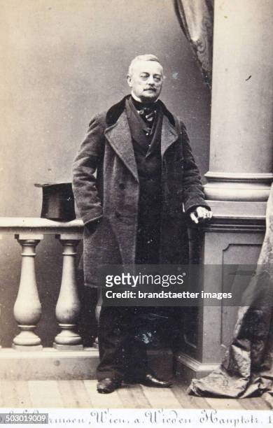 Gentleman in a frock coat. The right hand in his pocket, the cylinder on the Atelierbalustrade. Full figure. About 1861. Photograph of Geb. Harmsen /...