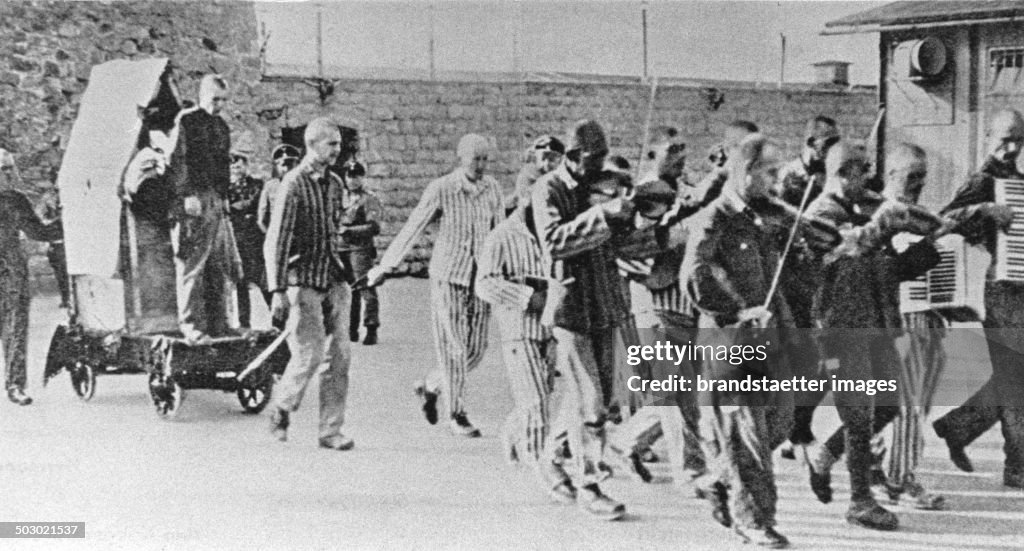 Prisoners Are Forced To Give Company To  Fellow Sufferers  With Happy Music  To Execution. Mauthausen Concentration Camp. Austria. Photograph. Ca. 1943.