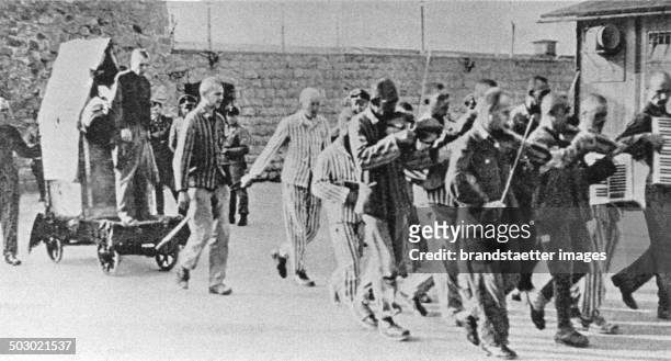 Prisoners are forced to give company to fellow sufferers with happy music to execution. Mauthausen concentration camp. Austria. Photograph. Ca. 1943....