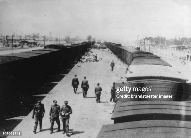 Trainstation of the concentration camp Auschwitz/Birkenau. Poland. In the background can be seen the crematoria No. 1 and No. 2. Photograph. 1944. .