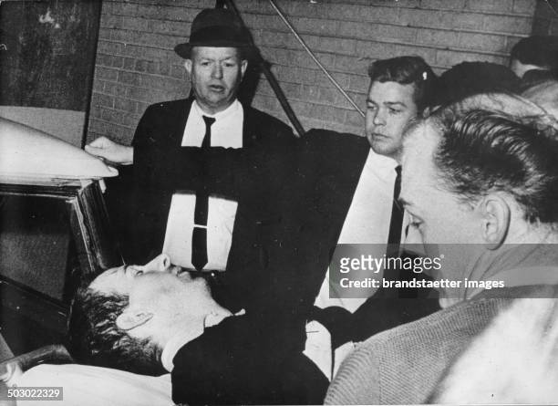 The alleged assassin Lee Harvey Oswald is being removed on strecher after being shot by the nightclub operator Jack Ruby two days after he had...